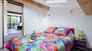 A bedroom with a large bed, a skylight, a view to the outside, and a purple nightstand with a lamp. - F2 holiday home in a corner of paradise with private pool and Wi-Fi (Céret)