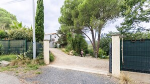 A gravel driveway leading to a gated entrance with a house in the background. - F2 holiday home in a corner of paradise with private pool and Wi-Fi (Céret)