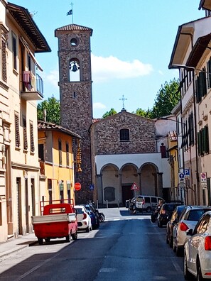 A street with parked cars, a church with a bell tower, and a pizza shop. - MILADY - COZY, ROMANTIC APARTMENT IN FLORENCE (Firenze)