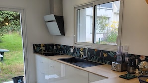 Una cocina moderna con encimera de madera, pileta integrada y ventana con vista a un jardín.