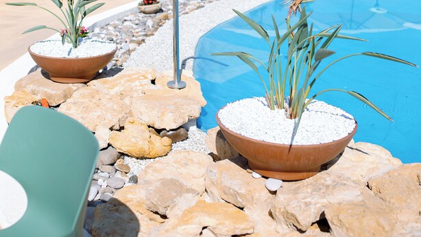 A poolside area with lounge chairs, umbrellas, and potted plants. - Agritourism. Accommodation x 2 people with outdoor kitchen, garden view (Mazzarino)