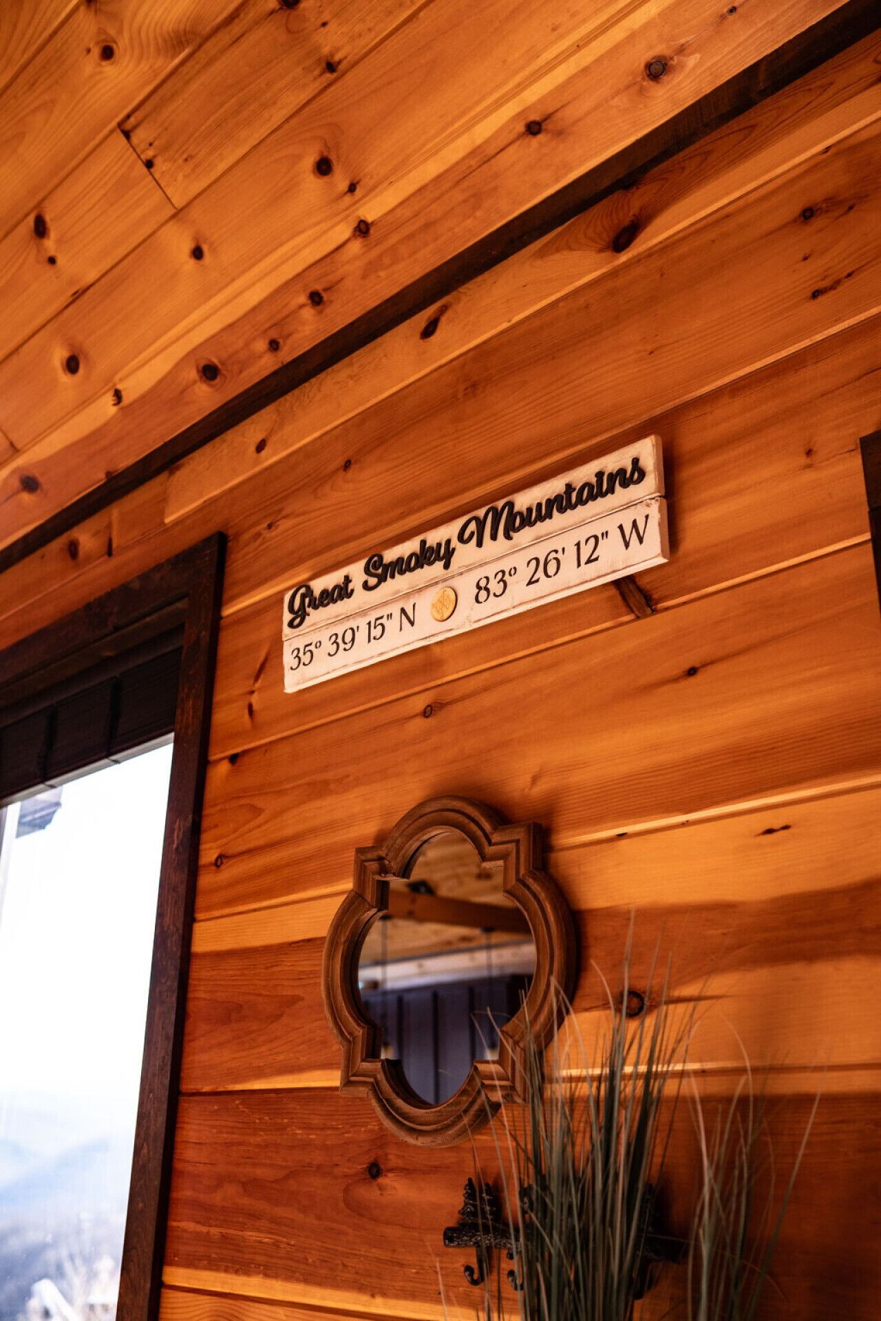 A wooden wall with a sign reading "Great Smoky Mountains 35° 39' 15" N 83° 26' 12" W".