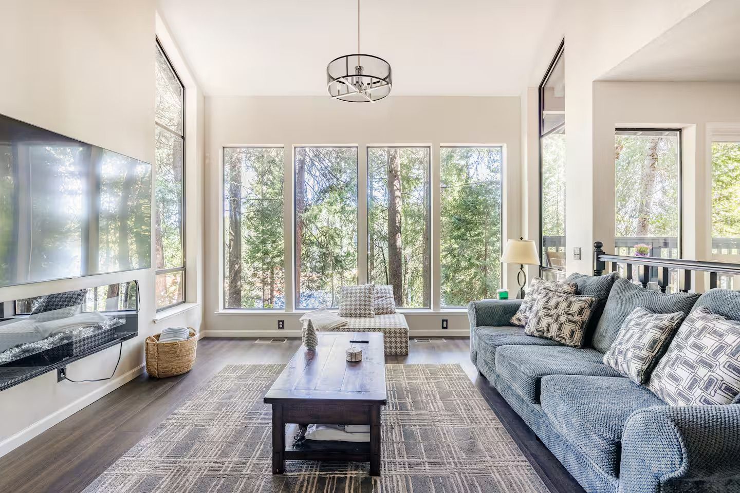A spacious living room with a large TV, a sofa, a coffee table, and a fireplace.