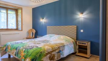 Una camera da letto con un letto, due comodini, una finestra con tende e un lampadario.