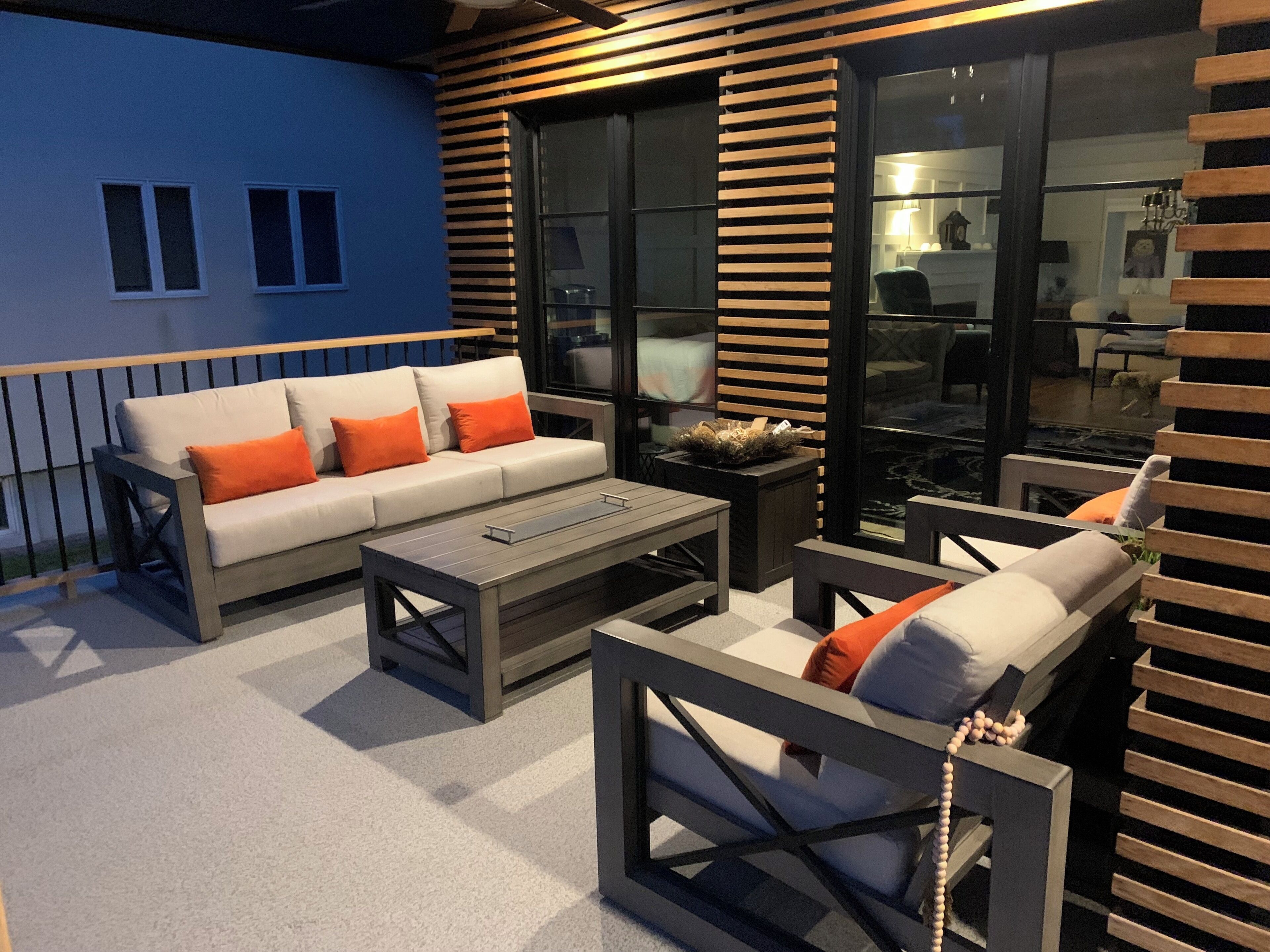 An outdoor seating area with a sofa, chairs, and a coffee table.