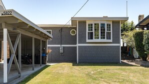 A two-story house with a covered porch and a fenced backyard.