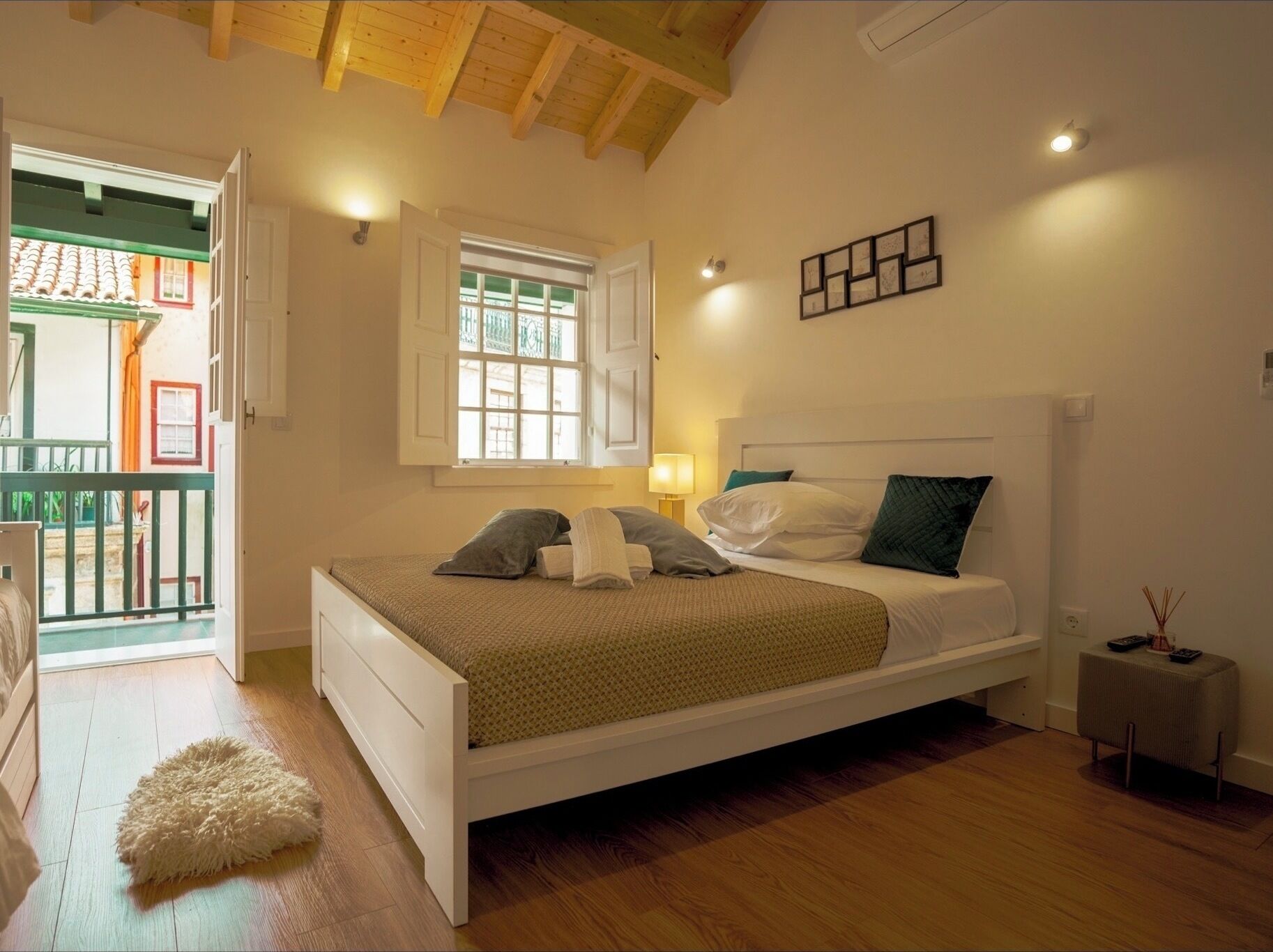 A bedroom with a bed, a window, a bedside table, and a small rug.
