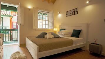 A bedroom with a bed, a window, a bedside table, and a small rug.