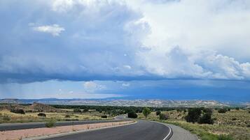 A curving road with a clear sky and distant cityscape.