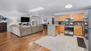 Een moderne keuken met houten kastjes, roestvrijstalen apparatuur en een centraal eiland.