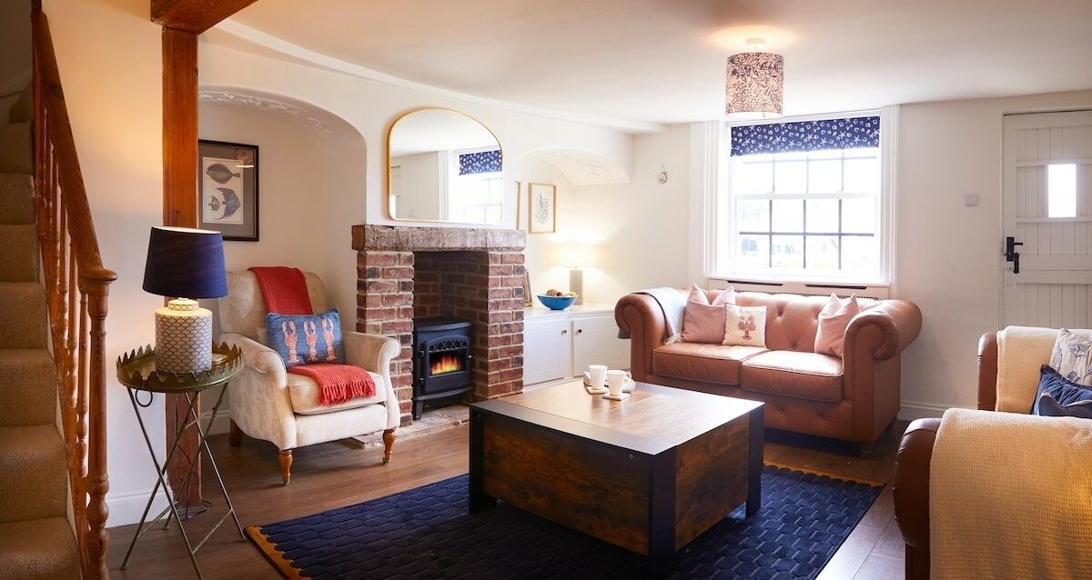 A cozy living room with a fireplace, a sofa, a coffee table, and a lamp.