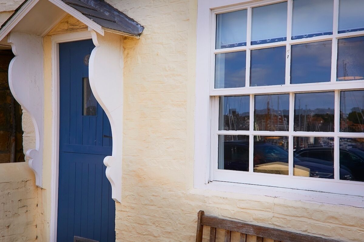 A building with a blue door and a window with multiple panes.