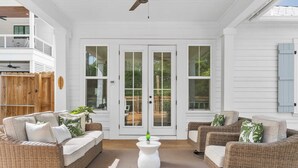 A covered patio area with wicker furniture and a central white table. - Sleeps 34! 2 Homes, Private Pools, Firepit, Golf Cart, Walk to Beach Seagrove San Juan by Avantstay (Santa Rosa Beach)