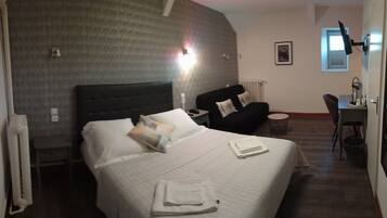 Habitación de hotel con una cama grande, un escritorio, una silla y un radiador.