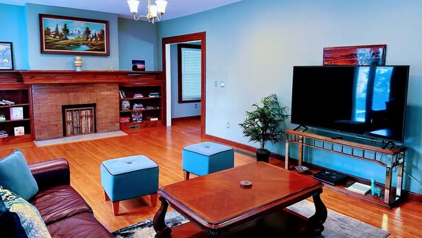 Una sala de estar con chimenea, televisor, sofá y mesa de centro.