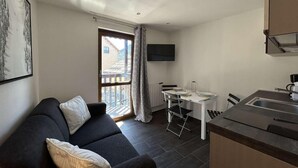 A compact living space with a sofa, a dining table, and a kitchen area. - 150m from ski slopes, 1st floor, view village, balcony, tv, ski locker, 20m², Montgenèvre (Montgenèvre)