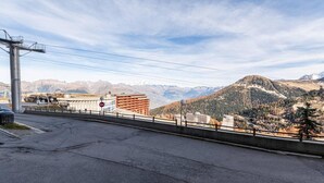 Une route avec un panneau indiquant « accès interdit », une glissière de sécurité et un paysage montagneux en arrière-plan.