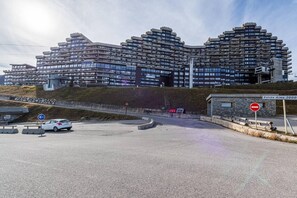 Un edificio moderno de varios pisos con un diseño arquitectónico singular, que cuenta con balcones y fachada de piedra.
