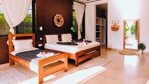 Un dormitorio con dos camas, cabecero de madera, un espejo y vistas al exterior.