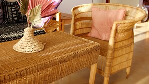 A wicker table with a woven centerpiece and a wicker chair with a pink cushion. - Private Villa with pool & tropical garden. 8 minutes' drive to Paje beach. (Paje)