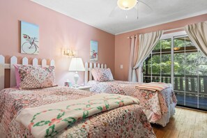A bedroom with a bed, a nightstand, a lamp, and a window with curtains.