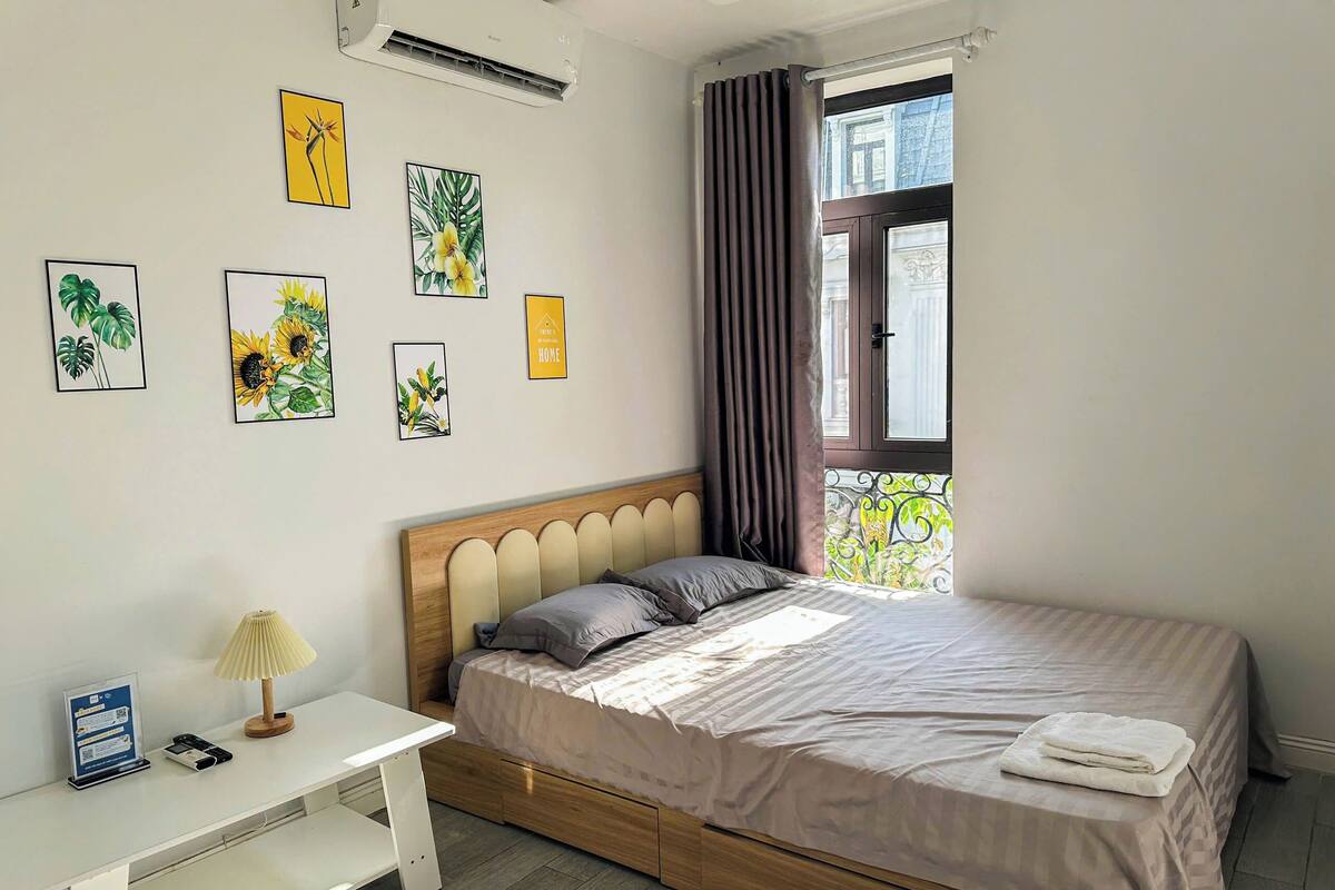 Une chambre bien rangée, avec un lit, une table de chevet et un bureau.