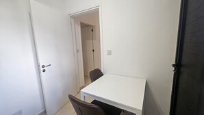 A small, white room with a single table and two chairs. - 106 NIC - Stay Kallisto Old Town Apartment (Nicosia)