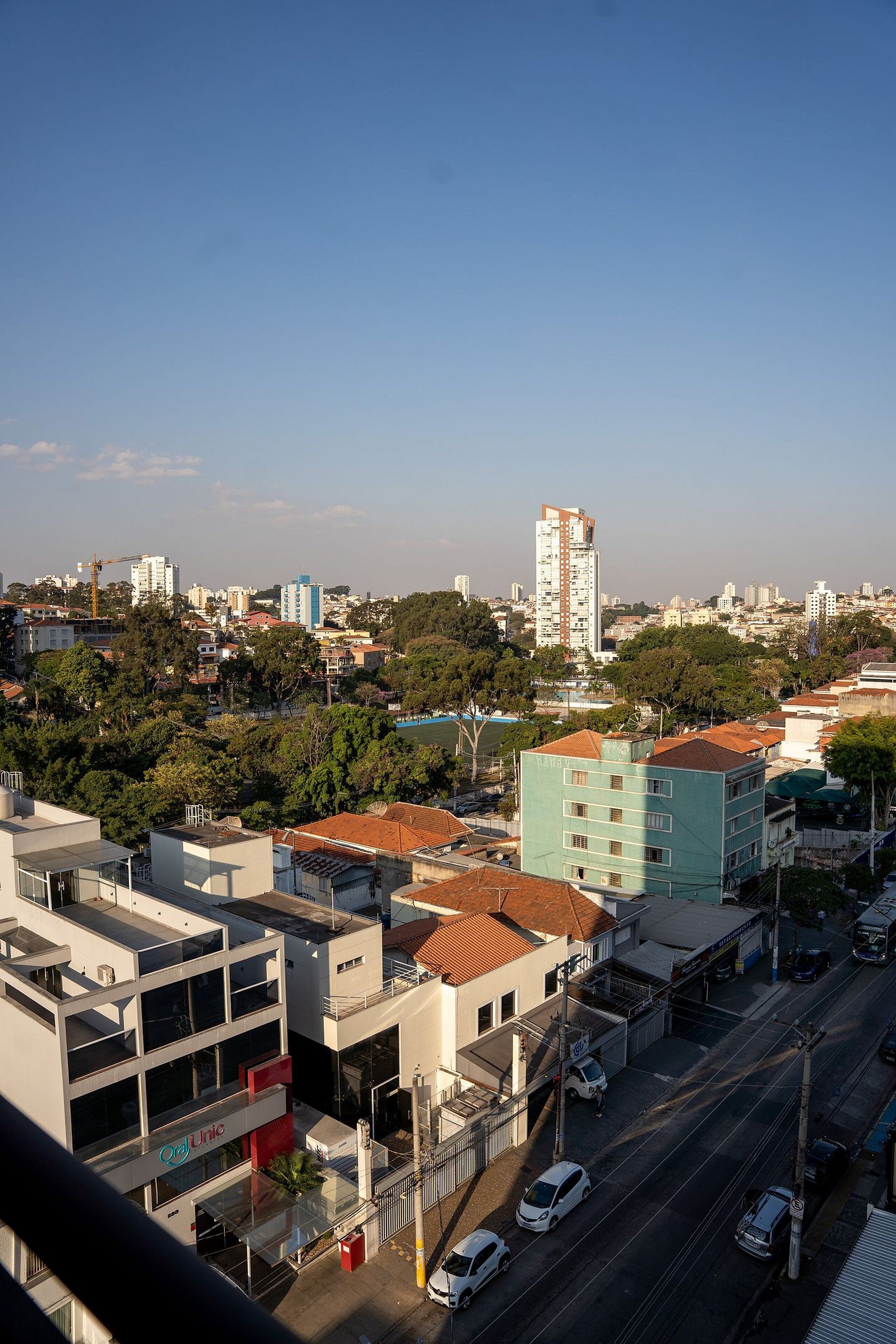 A cityscape with a mix of residential and commercial buildings, a prominent blue building, and a clear sky.