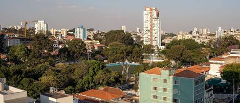 A cityscape with a mix of residential and commercial buildings, a prominent blue building, and a clear sky.