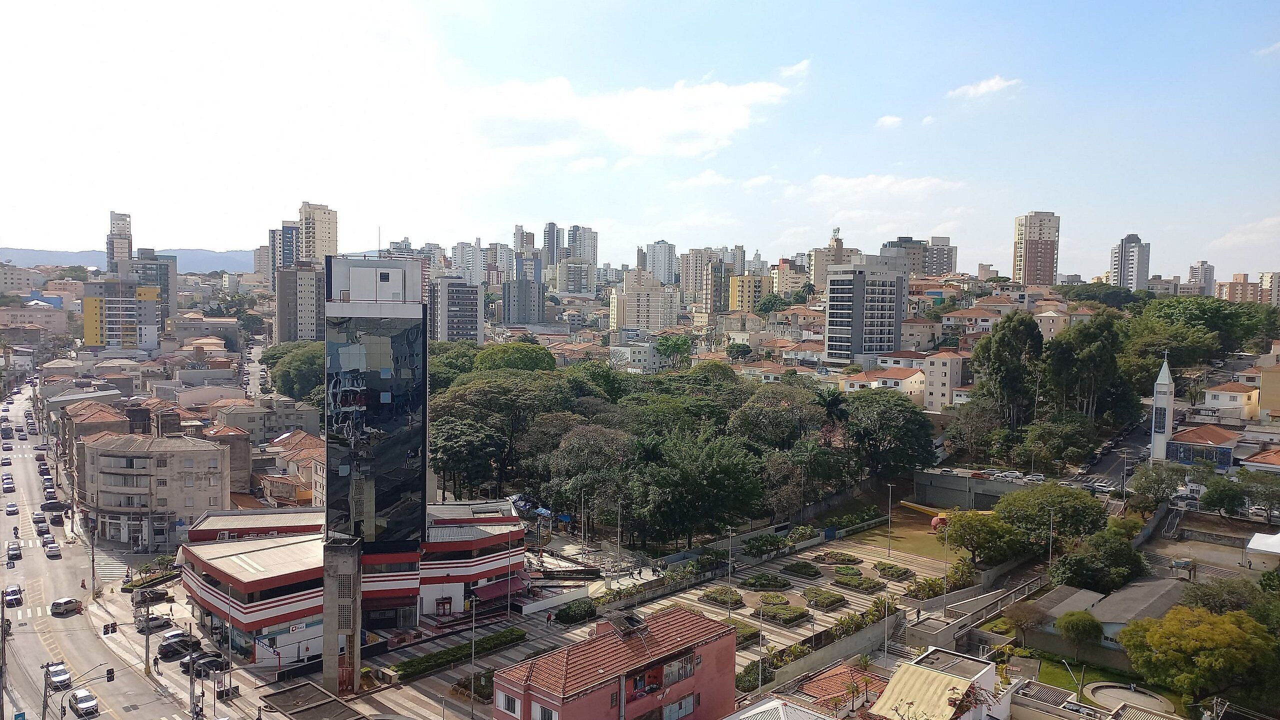 A cityscape with a prominent tall building featuring a unique facade.