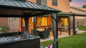 Een hottub in een overdekte buitenruimte, met een tafel en stoelen in de buurt.