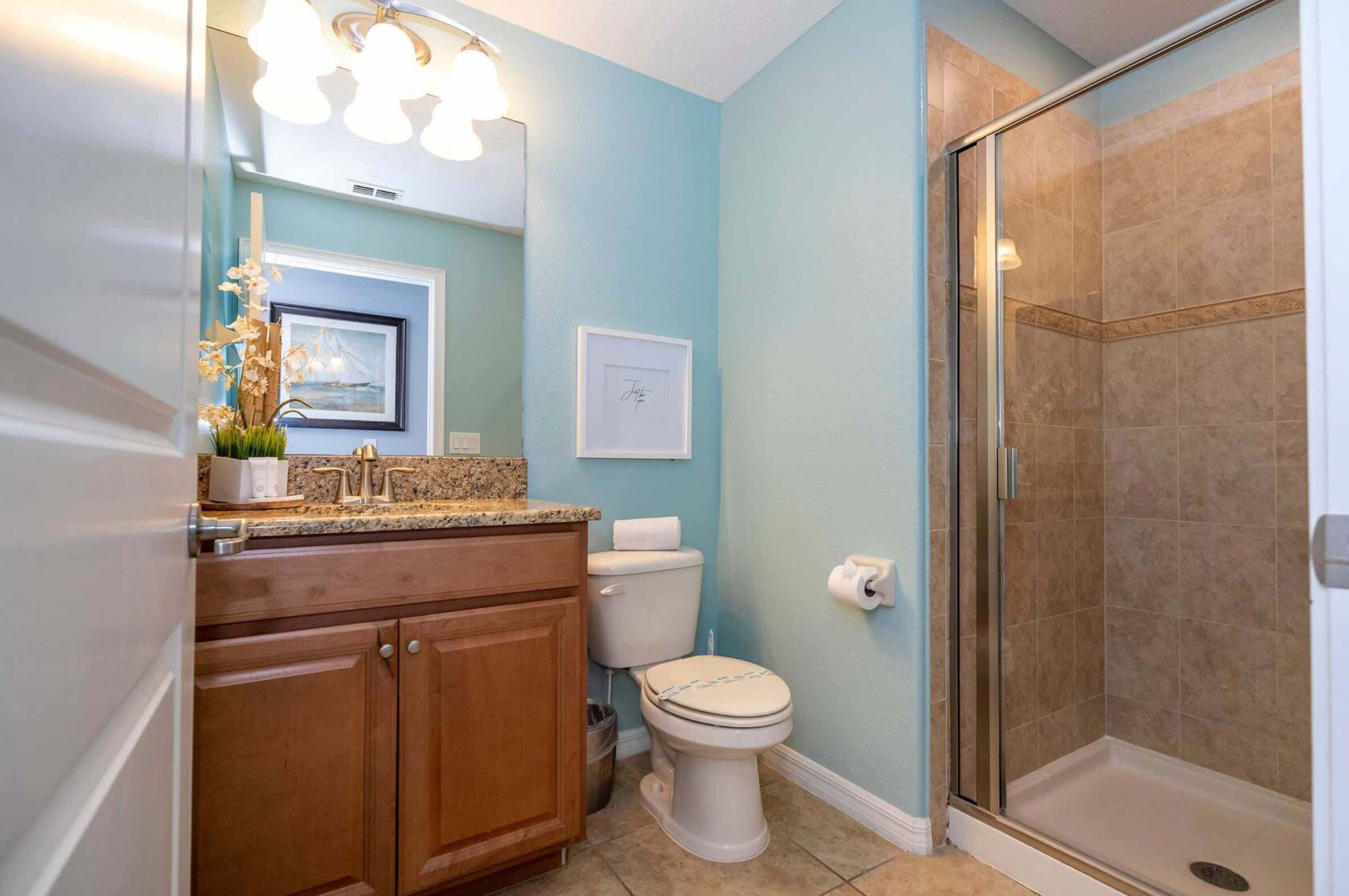 A bathroom with a toilet, a shower, and a sink with a countertop.