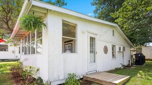 A white single-story house with a front porch, a small deck, and a garage.