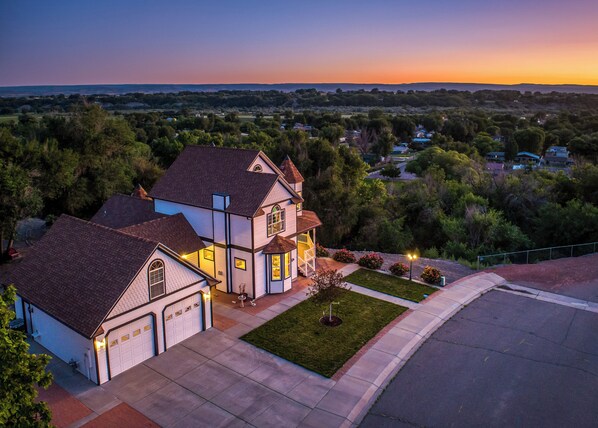 A two-story house with a garage, a well-maintained lawn, and a driveway.