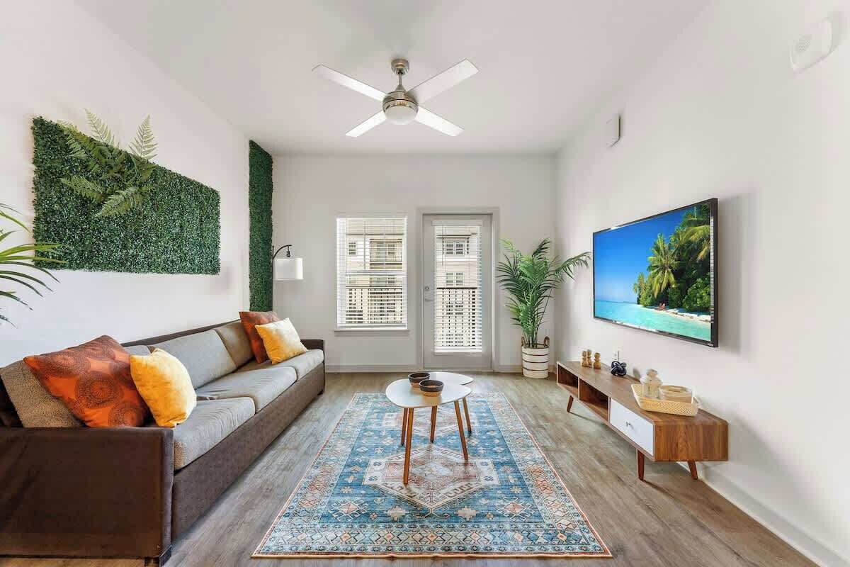 A modern living room with a sofa, coffee table, and a flat-screen TV.