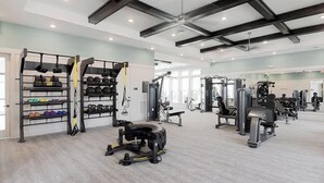A gym with various exercise equipment, including weight machines and free weights. - Cozy 2Bed Boho Hideaway 10 Min to Parks Allows Pet (Bay Lake)