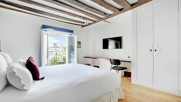 Ein Schlafzimmer mit Bett, Schreibtisch und Kleiderschrank.