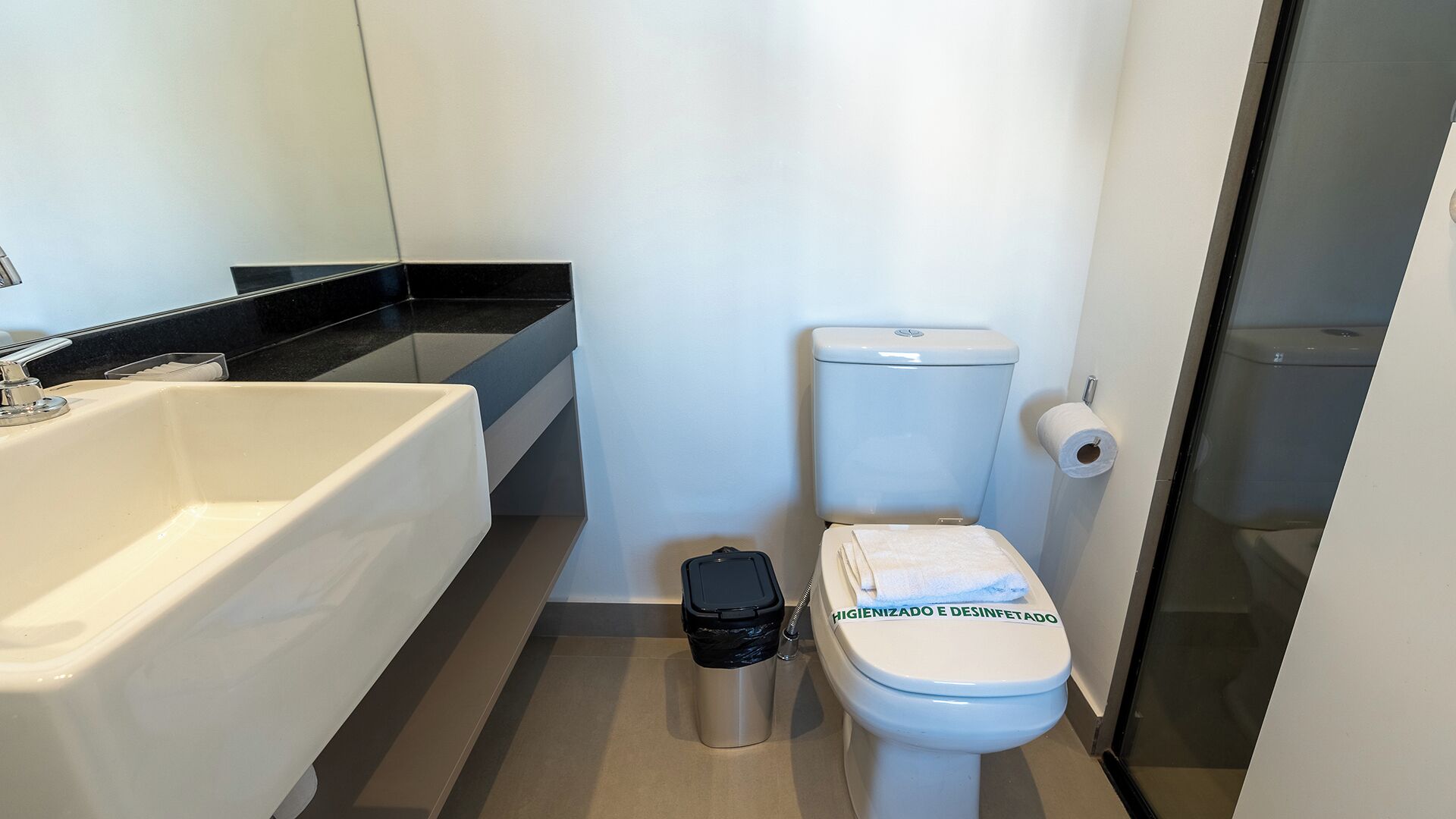 A bathroom with a white bathtub, a toilet, and a trash bin.