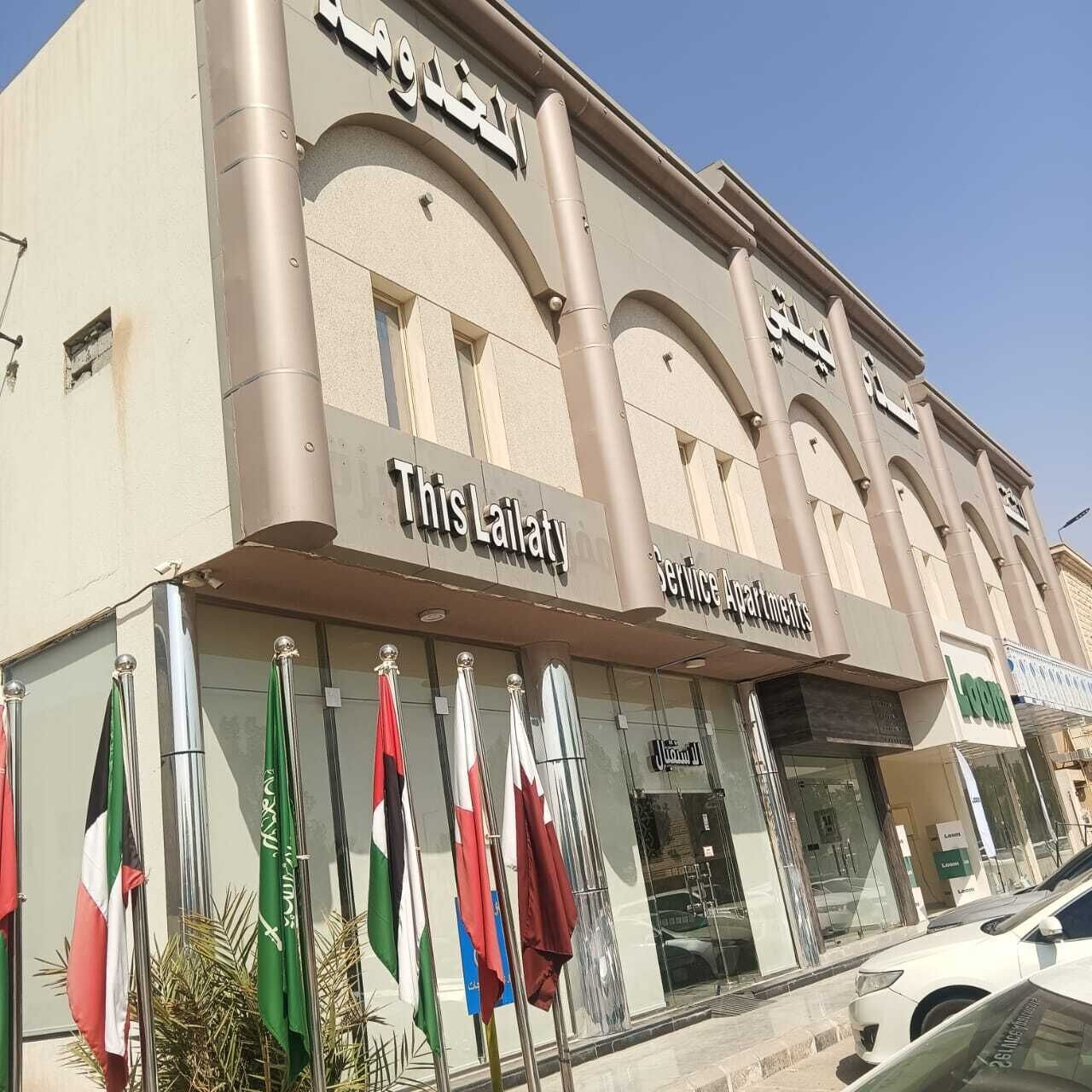A building with a sign reading 'This Lailaty' and 'Service Apartments'.