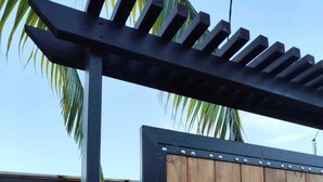 A wooden gate with the number 39, a plaque indicating a tourism award, and a palm tree in the background. - Small Creole Kaz with garden and jacuzzi, near Grande Anse beach (Petite-Île)