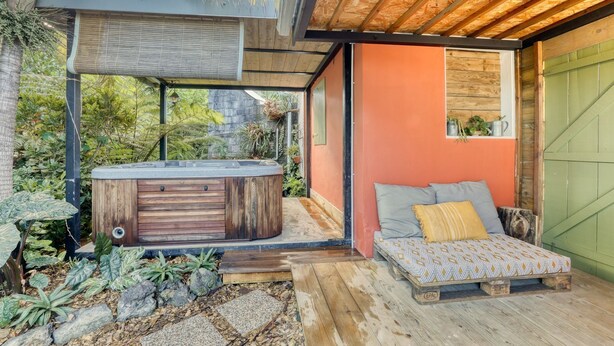 A cozy outdoor seating area with a wooden bench and a hot tub. - Small Creole Kaz with garden and jacuzzi, near Grande Anse beach (Petite-Île)
