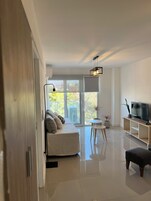 Una sala de estar moderna con un sofá, una televisión y un comedor.