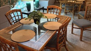 A dining area with a glass-top table, bamboo chairs, and woven placemats. -  Resort with best location in St. Augustine, FL-2BD/2BA Single Level (St. Augustine)