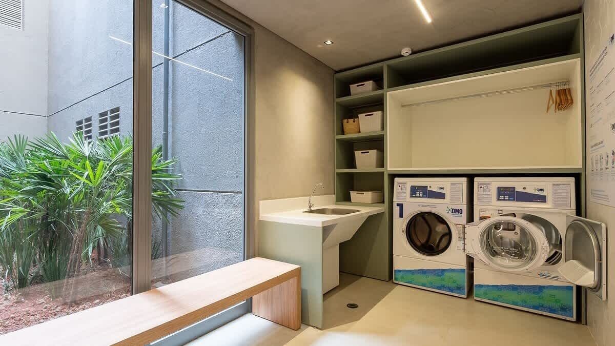 A laundry room with a sink, two washing machines, and shelves with boxes.