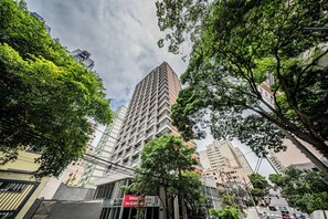A high-rise building with a distinctive zigzag pattern, surrounded by trees and other buildings. - Mode Perdizes (São Paulo)