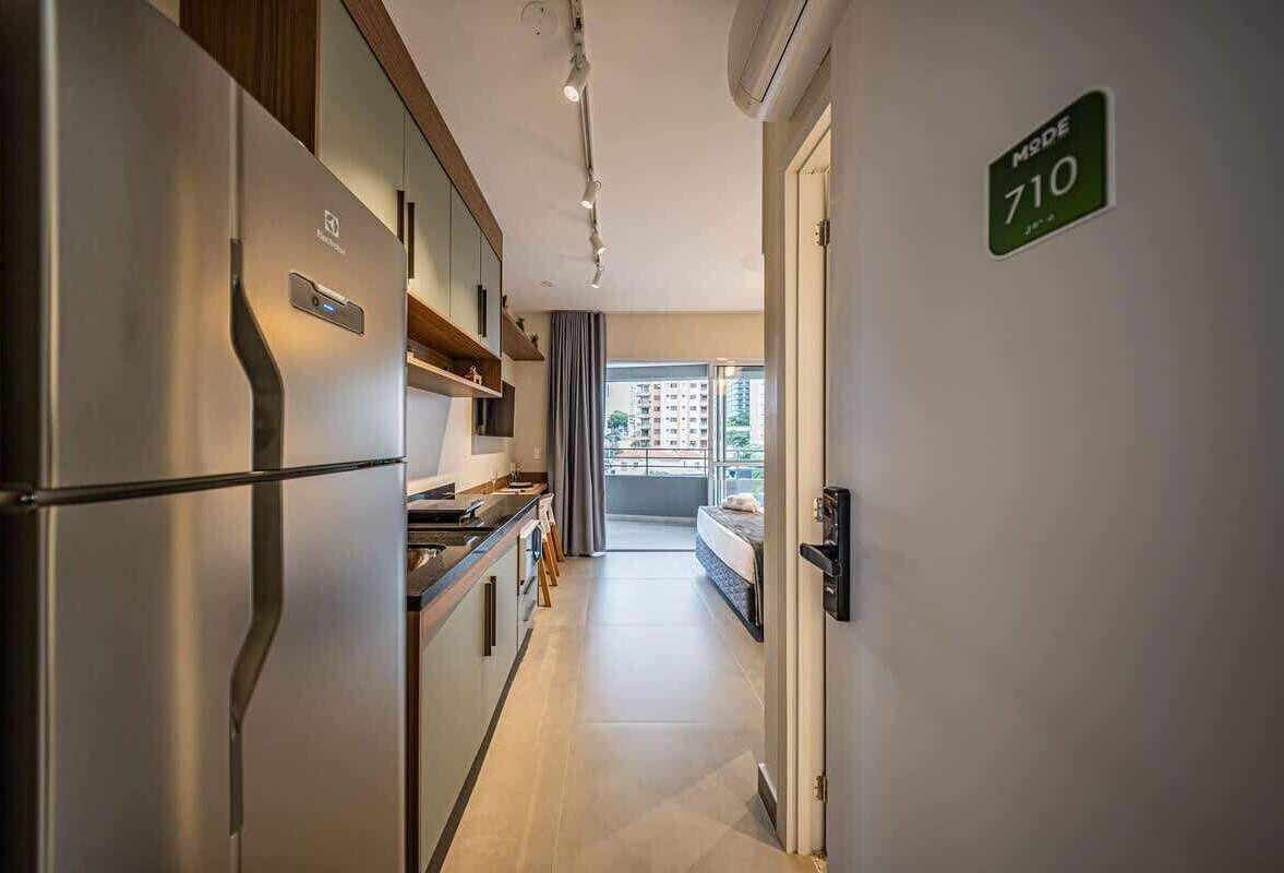 A modern kitchen with stainless steel appliances, a dining area, and a view to the outside.