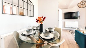A modern dining area with a glass table, chairs, and a vase of flowers. - Cozy 3-Bed Central Southampton (Shirley)