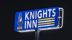 A sign for "Knights Inn" with a knight's helmet logo and the word "Arab" below it. - Arab Knights Inn (Arab)
