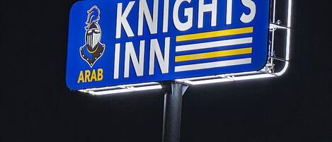 A sign for "Knights Inn" with a knight's helmet logo and the word "Arab" below it.