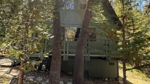 A cabin-like structure surrounded by trees, with a stone pathway leading to it. - La Forêt Retreat, Hiking, Lakes, Dog Friendly! (Running Springs)